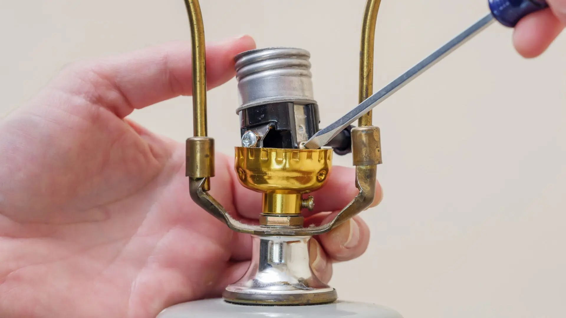 Artisan du luminaire raccordant une douille de lampe pour garantir la conformité électrique.